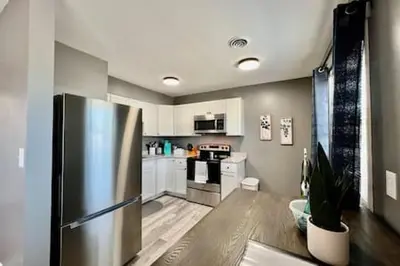 a kitchen with a stainless steel refrigerator and white cabinets at Sleek remodeled Design 2 Bed Trenton, OH Apartment in Trenton
