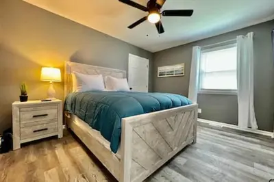 a bedroom with a bed and a ceiling fan at Charming, Stylish remodeled Trenton Apartment in Trenton