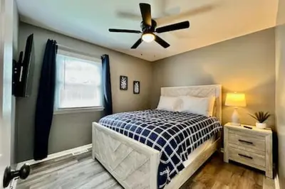 a bedroom with a bed and a ceiling fan at Charming, Stylish remodeled Trenton Apartment in Trenton