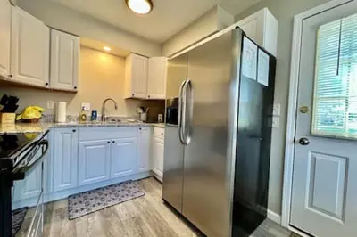 a kitchen with a stainless steel refrigerator next to a door at Remodeled 2 BDRM Ranch Attached Home Liberty, TWP in Rockdale