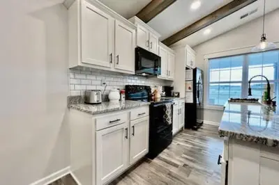 a kitchen with white cabinets and a counter top at Amazing riverside New Construction home in Middletown in Middletown