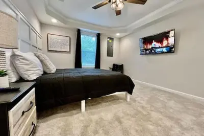 a bedroom with a bed and a tv on the wall at Amazing riverside New Construction home in Middletown in Middletown