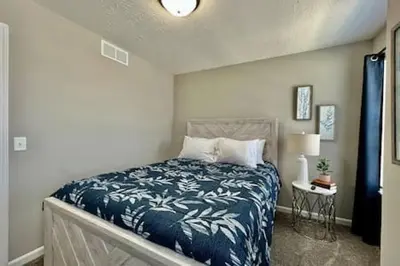 a bedroom with a bed with a blue blanket at Brand New Home Walking distance to Spooky Nook in Hamilton