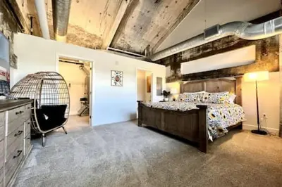 a bedroom with a bed and a bird cage at 5104 Cartridge Factory Loft in Maineville