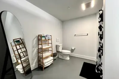 a white bathroom with a toilet and a shelf at 5104 Cartridge Factory Loft in Maineville