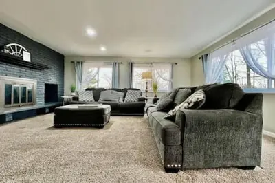 a living room with two couches and a fireplace at Beautiful home Among trees outside the city in Dent