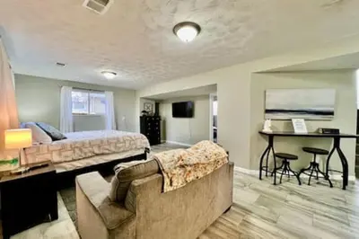 a bedroom with a bed and a couch and a table at Beautiful home Among trees outside the city in Dent