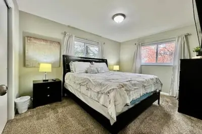 a bedroom with a large bed and two windows at Beautiful home Among trees outside the city in Dent