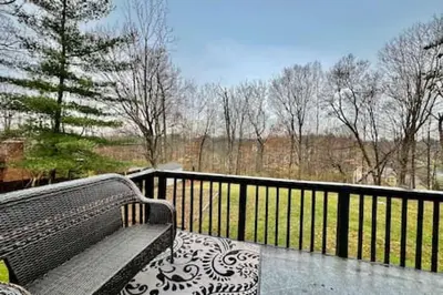 a bench sitting on a balcony with a fence at Beautiful home Among trees outside the city in Dent