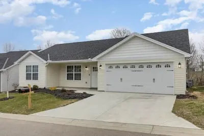 a white house with a large garage at Quietly nestled home among the Nook in Hamilton