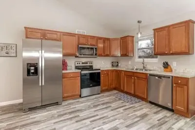 a kitchen with wooden cabinets and stainless steel appliances at Quietly nestled home among the Nook in Hamilton