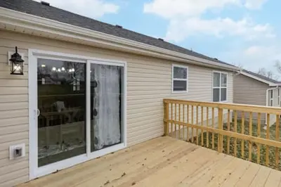 a house with a deck with a sliding glass door at BRAND NEW Home away from Home among the Nook in Hamilton