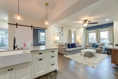 a kitchen with white cabinets and a living room at Charming Cincinnati Home with Spacious Deck! in Cincinnati