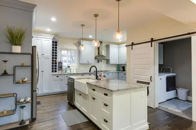 a kitchen with white cabinets and a sink at Charming Cincinnati Home with Spacious Deck! in Cincinnati