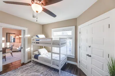 a room with bunk beds and a ceiling fan at Charming Cincinnati Home with Spacious Deck! in Cincinnati