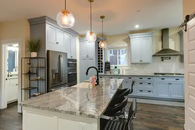 a kitchen with white cabinets and a granite counter top at Charming Cincinnati Home with Spacious Deck! in Cincinnati