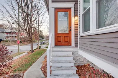 a house with a orange door and stairs at Charming Cincinnati Home with Spacious Deck! in Cincinnati
