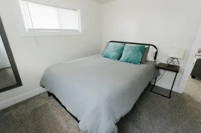 a bedroom with a bed with blue pillows and a window at Great Location in Dayton! Updated 1 bedroom/bath. in Dayton