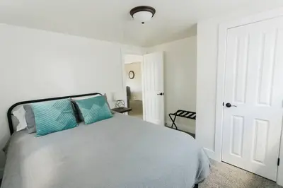 a white bedroom with a bed with blue pillows at Great Location in Dayton! Updated 1 bedroom/bath. in Dayton