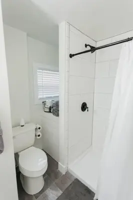 a white bathroom with a toilet and a shower at Great Location in Dayton! Updated 1 bedroom/bath. in Dayton