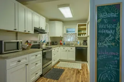 a kitchen with white cabinets and a blue wall at Hillside Hideaway in Logan