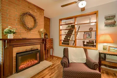 a living room with a fireplace and a chair at Hillside Hideaway in Logan