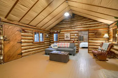 a living room in a log cabin with a couch at Russell Cabin in Logan