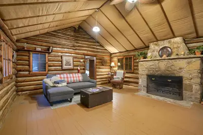 a living room with a fireplace in a log cabin at Russell Cabin in Logan
