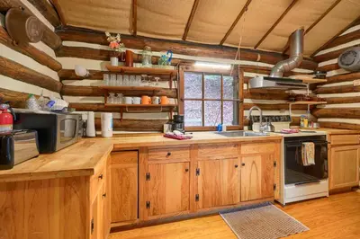 a kitchen with wooden cabinets and a stove top oven at Russell Cabin in Logan
