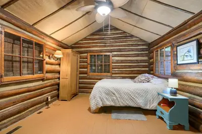 a bedroom with a bed in a log cabin at Russell Cabin in Logan