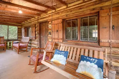 a porch with a bench and chairs in a cabin at Russell Cabin in Logan