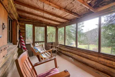a porch of a cabin with rocking chairs and windows at Russell Cabin in Logan