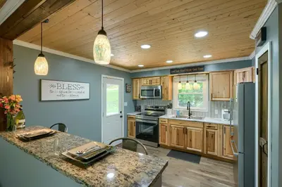 a kitchen with wooden cabinets and a counter top at Hideaway Pines in Logan