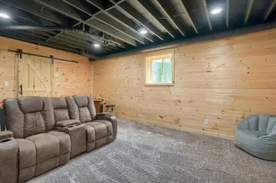 a living room with a couch and two chairs at Hideaway Pines in Logan