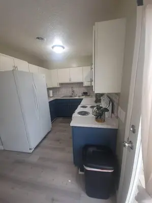 a small kitchen with white appliances and blue cabinets at Hidden Gem close to Athens/Logan in Nelsonville