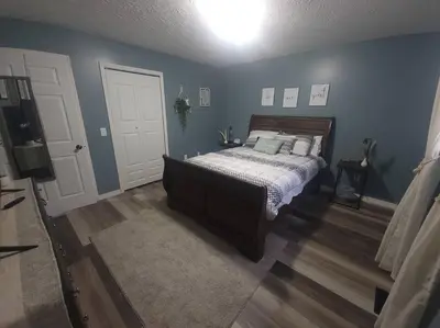 a bedroom with a bed and a blue wall at Hidden Gem close to Athens/Logan in Nelsonville