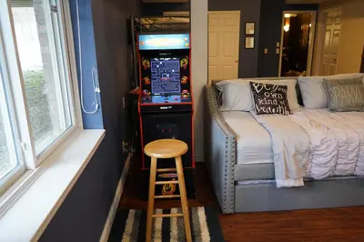 a room with a video game machine next to a bed at Walkout Basement Near Creation Museum in Hebron