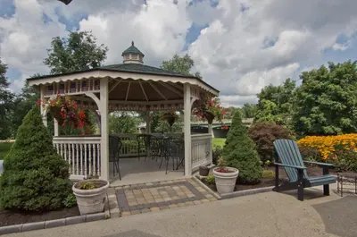 a gazebo with a table and chairs in a garden at Coshocton Village Inn & Suites in Coshocton
