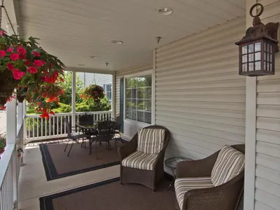 a screened in porch with two chairs and a table at Coshocton Village Inn & Suites in Coshocton