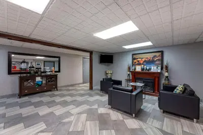 a waiting room with two chairs and a fireplace at Quality Inn Austintown-Youngstown West in Youngstown