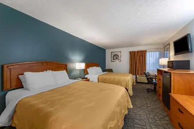 a hotel room with two beds and a flat screen tv at Quality Inn Austintown-Youngstown West in Youngstown
