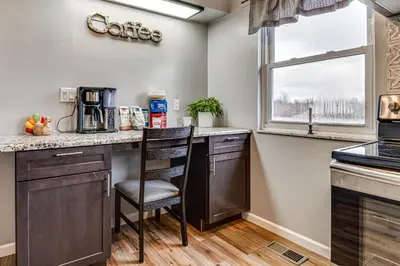 a kitchen with a counter with a chair and a window at 7 Mi to Depot District Richmond Home with Fire Pit in Richmond