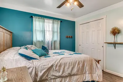 a bedroom with a bed with blue walls and a ceiling at 7 Mi to Depot District Richmond Home with Fire Pit in Richmond