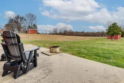 a black rocking chair sitting next to a field at 7 Mi to Depot District Richmond Home with Fire Pit in Richmond