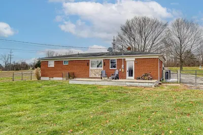 a small brick house with a porch in a field at 7 Mi to Depot District Richmond Home with Fire Pit in Richmond