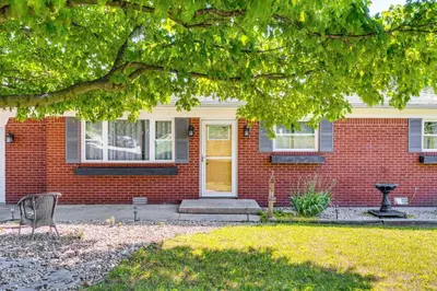 a red brick house with a yellow door at 7 Mi to Depot District Richmond Home with Fire Pit in Richmond