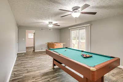 a pool table in a living room with a ceiling fan at Spacious Delaware Home with Game Room! in Delaware