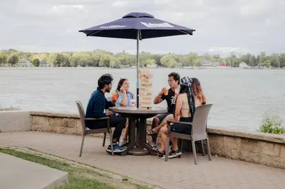a group of people sitting at a table under an umbrella at Bayshore Resort At Put-In-Bay in Put-in-Bay