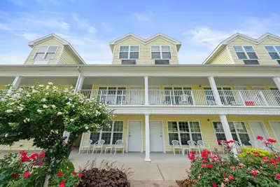 a large yellow house with chairs and flowers at Kelleys Island Venture Resort in Kelleys Island
