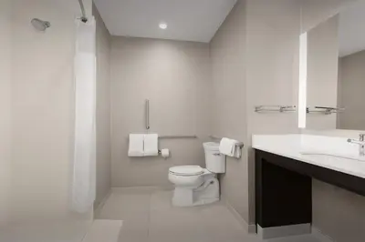 a white bathroom with a toilet and a sink at Residence Inn by Marriott Kenwood Cincinnati in Kenwood